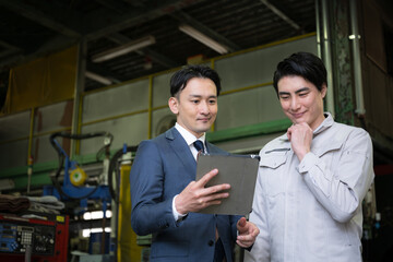 タブレットを確認する二人の社員